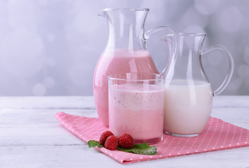Glass jug of milk cocktail with raspberry taste