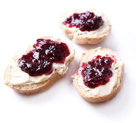 Fresh bread with blackcurrant jam and homemade butter, isolated