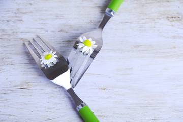 Fork with daisy flower, on wooden background