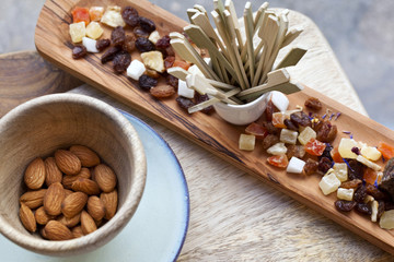 Fototapeta na wymiar Almonds and dried fruit on a wooden tray