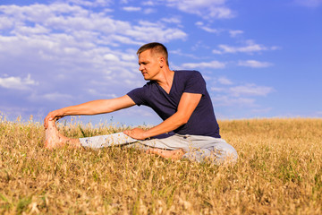 Young man relaxing on the sunny meadow.