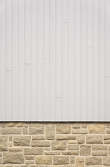 Hintergrund Mauer aus Natursteinimitat und Lattenzaun