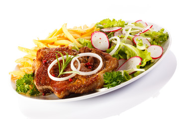 Grilled sausages, French fries and vegetables
