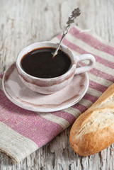 Baguette and cup of coffee on the wooden board
