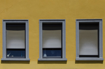 Fototapeta na wymiar trois fenêtres sur fond jaune