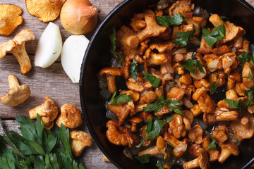 chanterelle mushrooms with onion and parsley  in a pan top view - obrazy, fototapety, plakaty