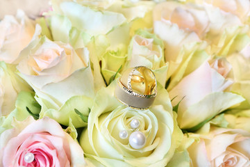 Golden wedding rings on the bouquet of roses