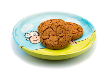 Smiling sheep underneath cookies on a colorful plate