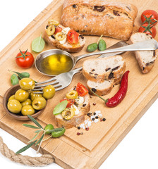 .Olive oil with green olives and bread on a wooden  board