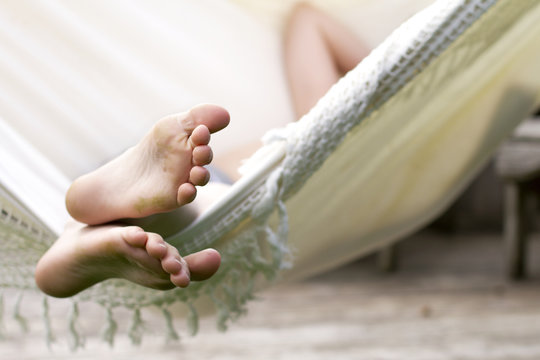 Kind met vieze voeten relaxt in hangmat