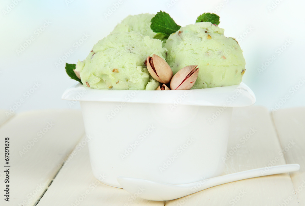 Wall mural tasty ice cream scoops in bowl, on wooden table