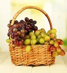 Fresh grape on wicker mat on bright background