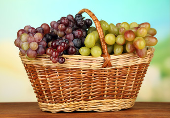 Fresh grape on wicker mat on bright background