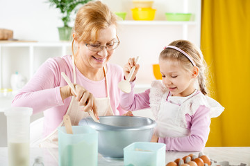 Obraz na płótnie Canvas Senior woman with little girl making Dough.
