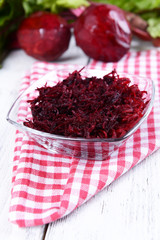 Grated beetroots in bowl on table close-up