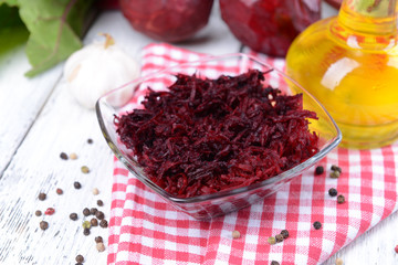 Grated beetroots in bowl on table close-up