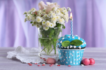 Tasty cupcake on table, on fabric background