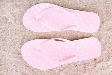 Color flip-flops on sand background