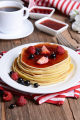 Sweet pancakes with berries on table close-up