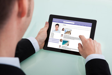 Businessman Surfing Social Networking Site On Digital Tablet