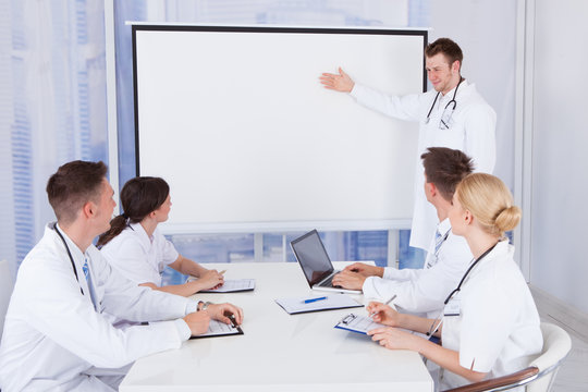 Male Doctor Giving Presentation To Colleagues In Hospital