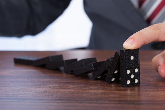 Businessman Playing Domino On Desk