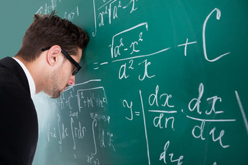 Professor Leaning Head On Blackboard