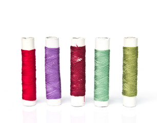 Spools of colours threads isolated on white background