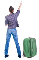 traveling young woman with suitcas pointing at wall.