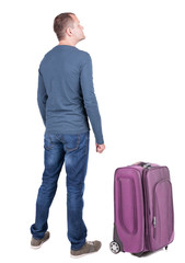 Back view of young man traveling with suitcas.