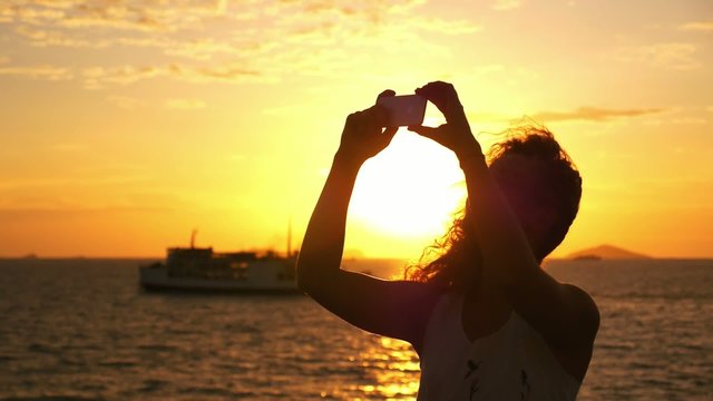 Beautiful Woman Taking Selfie against Sunset during Sea Cruise.