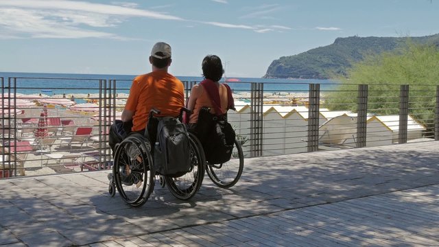 couple at the beach with wheelchairs
