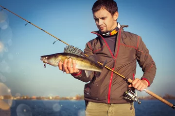 Raamstickers Happy angler with zander fishing trophy © vitaliy_melnik