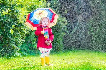 Little happy girl playing in the rain