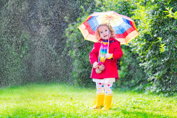 Little funny girl playing in the rain