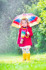 Little beauiful girl playing in the rain