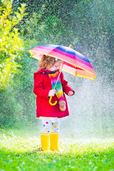 Little adorable girl playing in the rain