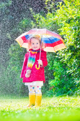 Little cute girl playing in the rain