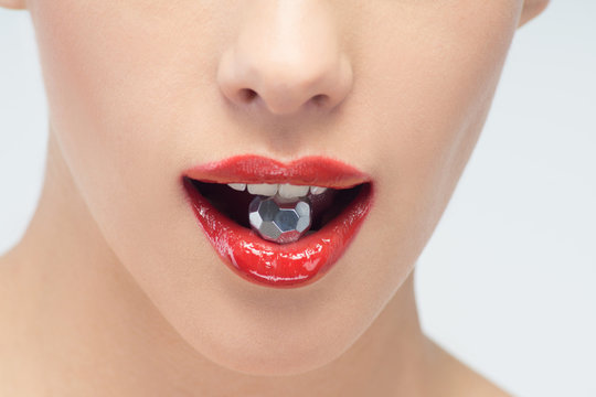Young beautiful woman with metallic ball in mouth