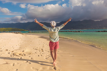 man walking on the beach and celebrates his joyous life