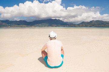 Fototapeta na wymiar back of a young man resting on the beach