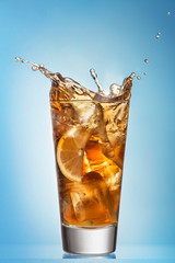 Glass of splashing iced tea with lemon