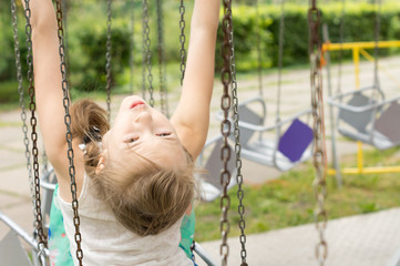 Young girl playing on a swing