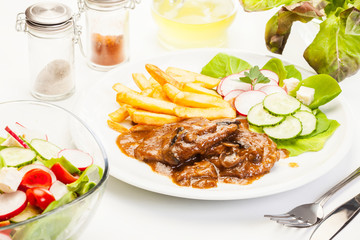 Pork chop with sauce, mushrooms and chips