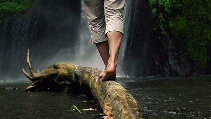 Man walking on wood log by waterfall, super slow motion, 240fps - Powered by Adobe