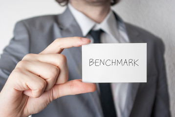 Benchmark. Businessman showing business card