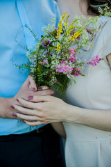 Obraz na płótnie Canvas wedding: Bride and groom holding hands with bouquet