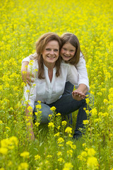 Fototapeta premium Mutter und Kind im Rapsfeld im Frühjahr