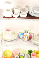 Different tableware on shelves, isolated on white