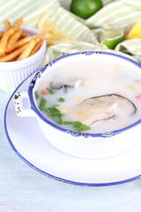 Tasty soup with oysters on wooden table